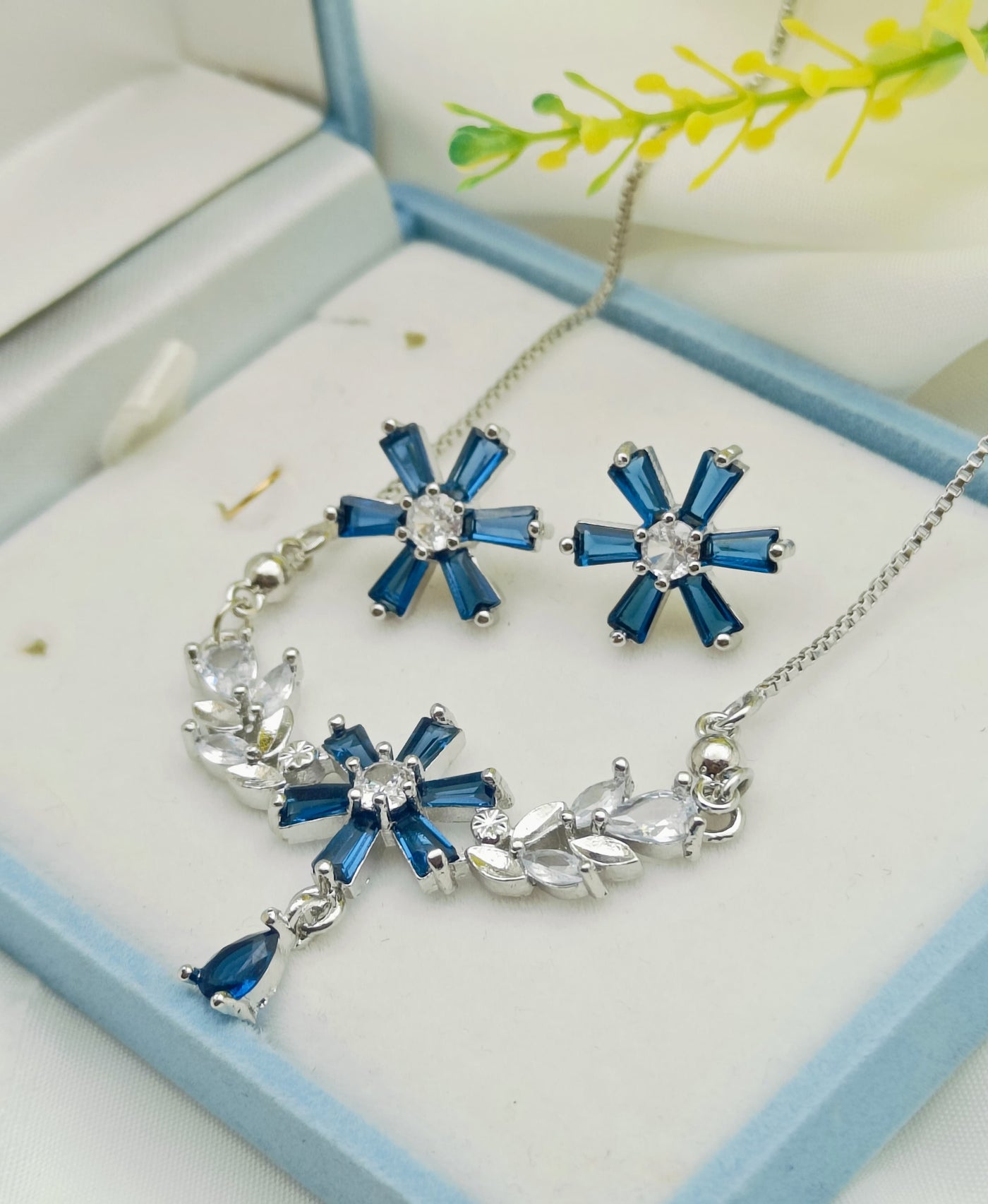 Silver-toned jewelry set featuring a necklace and matching stud earring